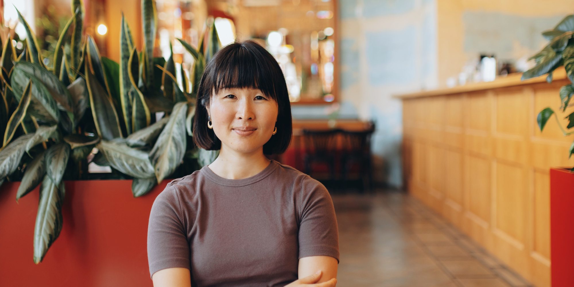Sumire Sato writing, surrounded by language phrasebooks