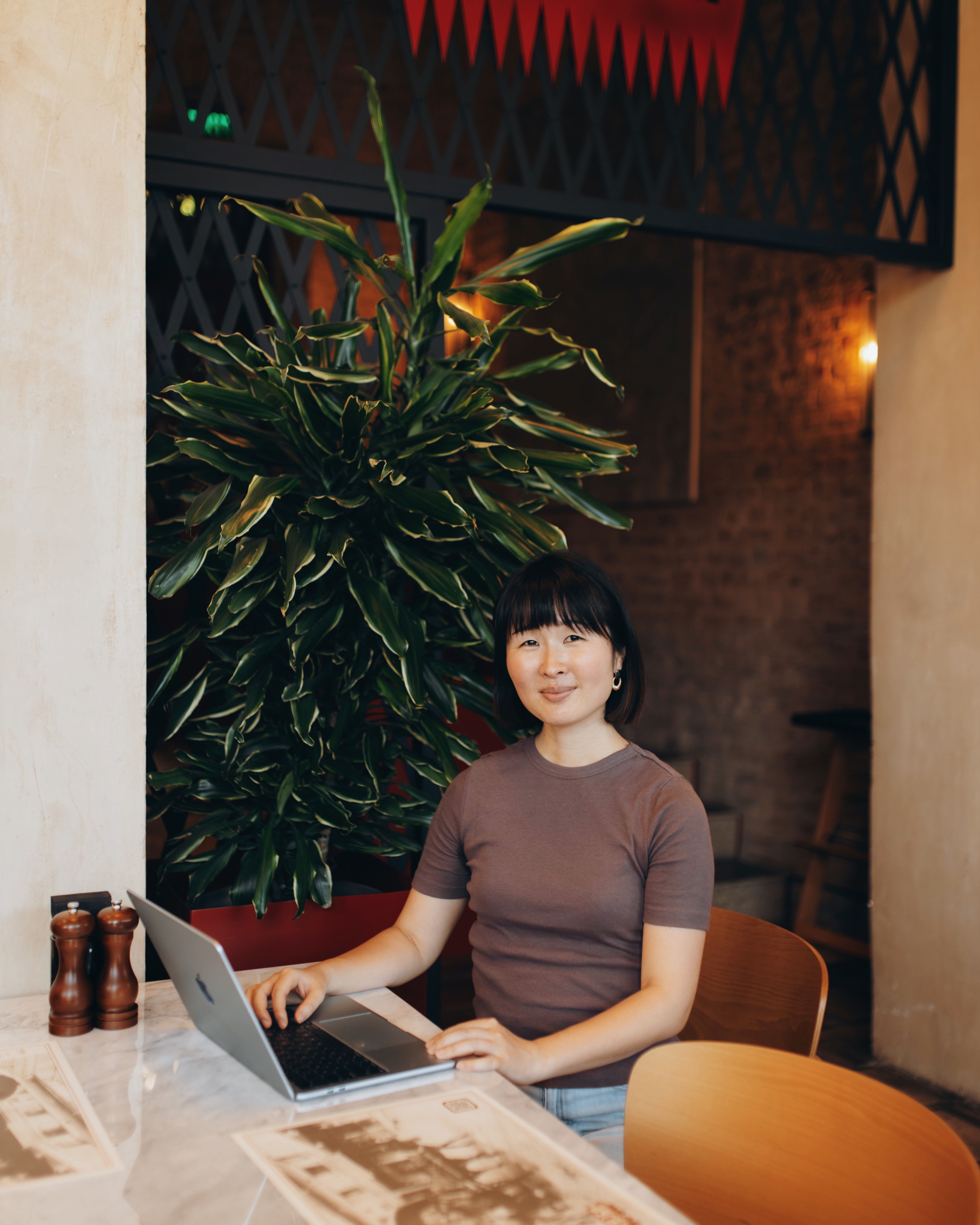 Sumire Sato working on a laptop in a café